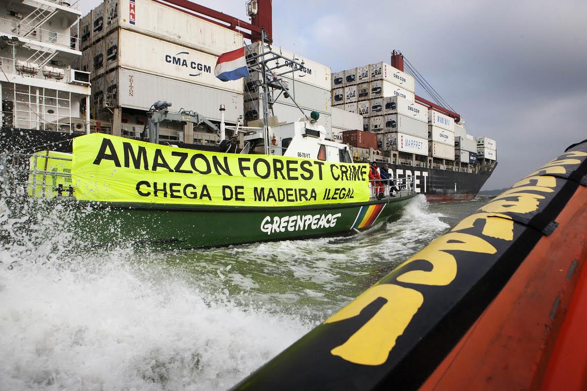 Greenpeace Netherlands activists aboard inflatables and the Greenpeace vessel, Argus confront a cargo ship carrying Amazon timber, purchased from a sawmill known for trading in illegal wood as it approaches Rotterdam. Banners read: 'Amazon Forest Crime'. The timber onboard is destined for Belgian companies; Lemahieu and Omniplex and was sourced from the Brazilian sawmill and exporter Rainbow Trading by the Belgian timber company Leary Forest Products.