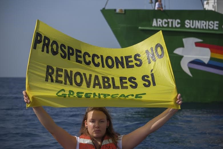 Una activista señala el punto donde Repsol pretende perforar en el mar de Alborán.