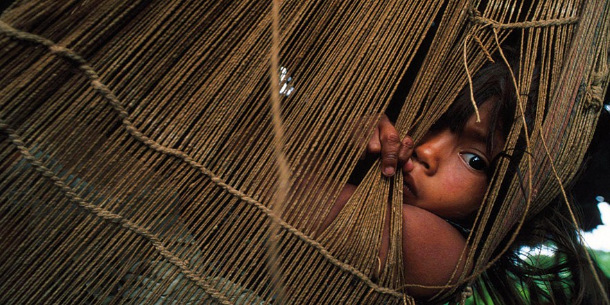 Un niño del pueblo deni tumbado en una hamaca