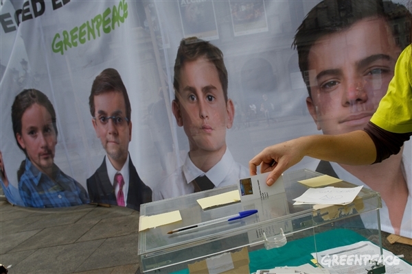 Lona en la que se ve a los "niños políticos" mientras una persona deposita sus propuestas. Foto: Pablo Blázquez