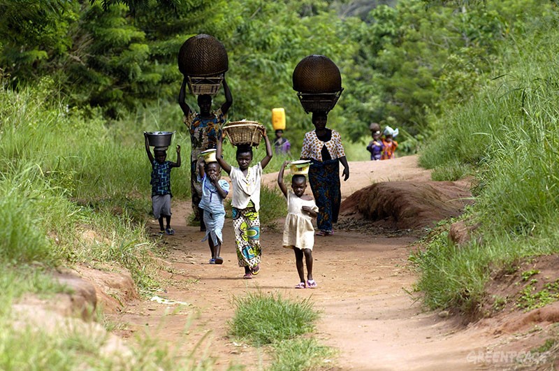 mujeres y niño transportando agua