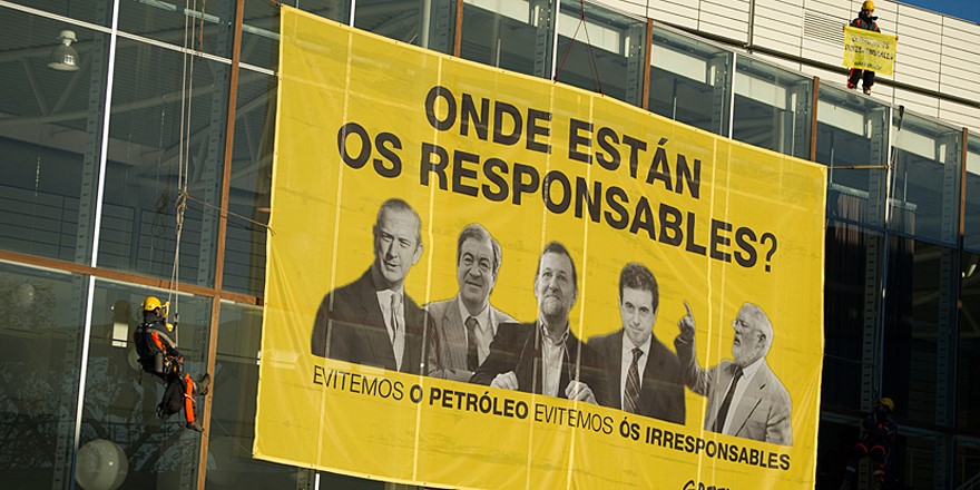 Cuatro activistas desplegaron una pancarta de sesenta metros cuadrados en Expocoruña, lugar donde se celebra el juicio.