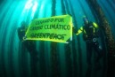 Buceadores de Greenpeace despliegan una pancarta bajo una batea de mejillones con el mensaje "cerrado por cambio climático”"