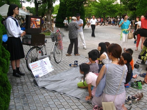 Una joven explica la historia de Sadako Sasaki a un grupo de niños en Hiroshima